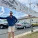 Josh Streets from Josh Streets Automotive standing under a large outside the front of his caryard. Cars can be seen behind him.