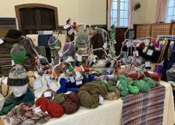 Spinning in Deloraine. The spinners and weavers showcase their work on a table.