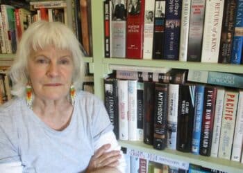 Patsy Crawford in front of a bookshelf filled with books.