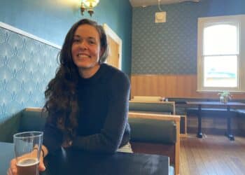 Hop to Harvest - Emma Seddon sitting at a table with a beer in The British pub in Deloraine, Tasmania