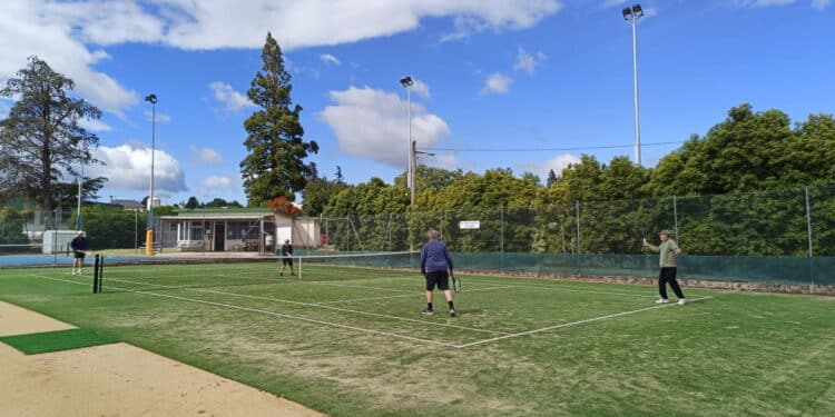 playing doubles tennis on the grass court at Deloraine
